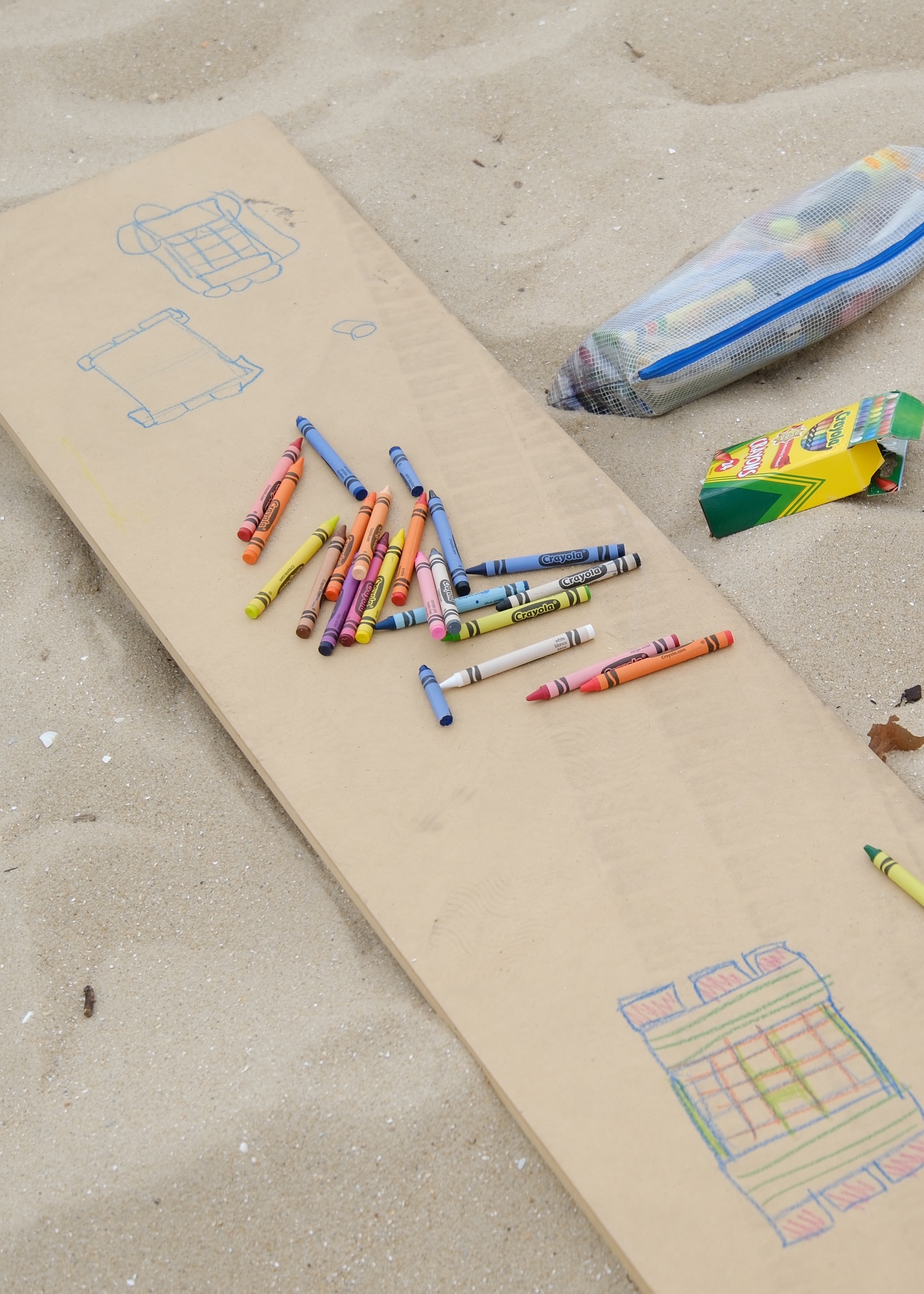 Crayons and a wooden plank with raft designs drawn on it.